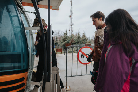 Friends enjoying a winter outing together boarding a gondola liftの写真素材