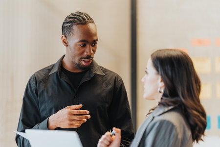 Diverse business people engaging in a collaborative discussion during a work meeting in a modern office settingの写真素材