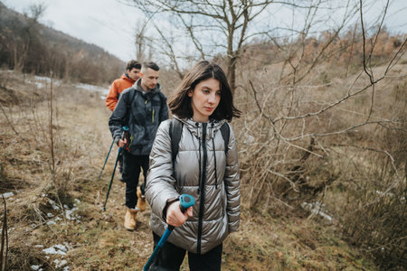 Group of friends hiking through a forest trail during autumnの写真素材
