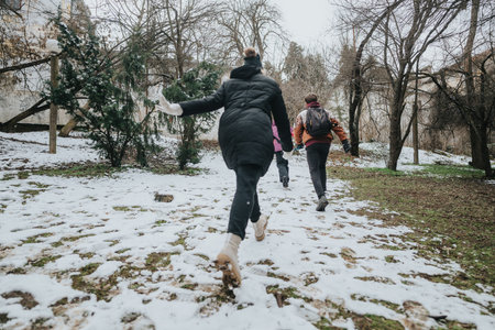 Friends exploring a snowy winter day outdoors amidst trees and natureの写真素材