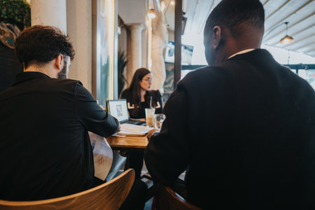 Business professionals collaborating together in a casual meeting setting within a cafeの写真素材