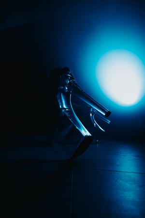 Transparent high heels on a dark floor with a blue back lightの写真素材