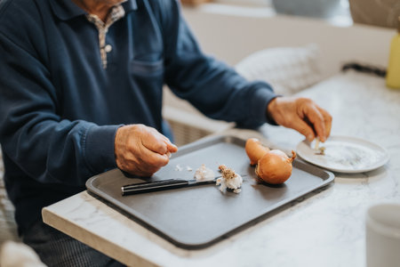 Senior man preparing vegetables at a kitchen table for cooking