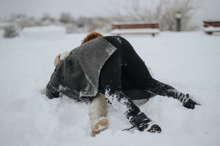 Two people enjoying playful time in the snow during a winter dayの写真素材