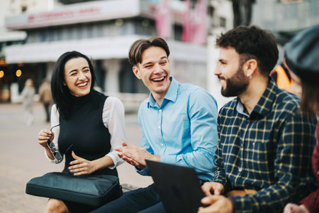 Young professionals enjoying a light-hearted conversation outdoorsの写真素材