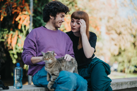 Young couple enjoying a relaxing afternoon with their cat outdoorsの写真素材