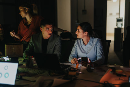 Multicultural team working late to meet a crucial business deadlineの写真素材