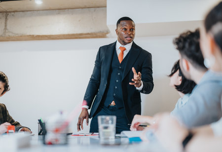 Professional businessman delivering a presentation to a team in a modern conference roomの写真素材