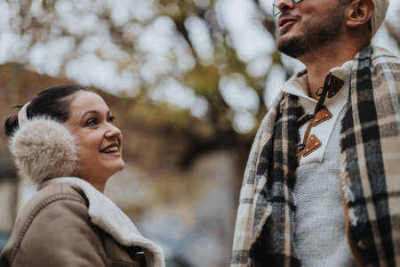 Happy couple enjoying a joyful moment outdoors during autumn seasonの写真素材