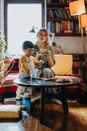 Mother and Child Enjoying Leisure Time Together in a Cozy Living Room Settingの写真素材
