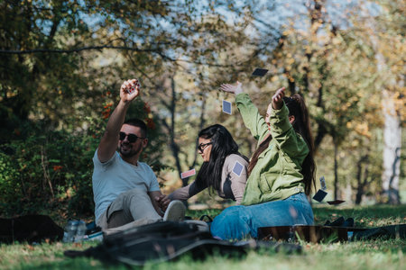 Group enjoying a playful day outdoors with cards in natureの写真素材