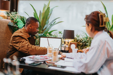 Collaborative brainstorming session between colleagues in a modern cafe settingの写真素材