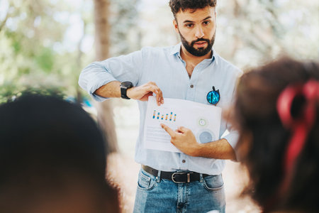 Young professional discussing business charts in outdoor meeting
