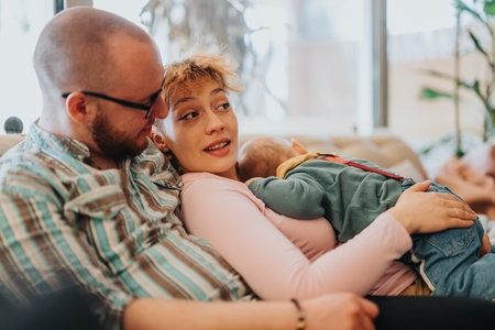 Young family enjoying quality time together at home with parents embracing their child