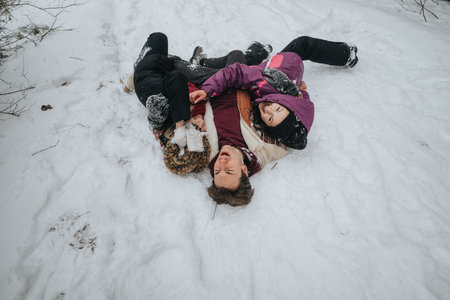 Group of friends enjoying time outdoors in the snow-covered winter landscapeの写真素材