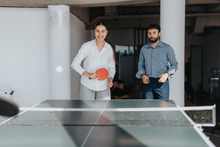 Business colleagues enjoying a friendly ping pong match together