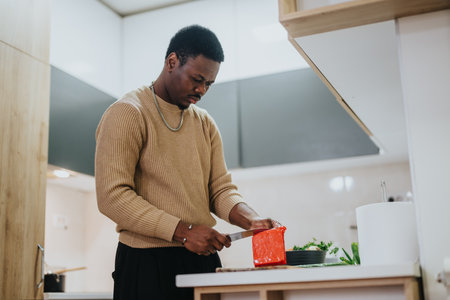 Man preparing food in a modern kitchen showcasing culinary skills at homeの写真素材