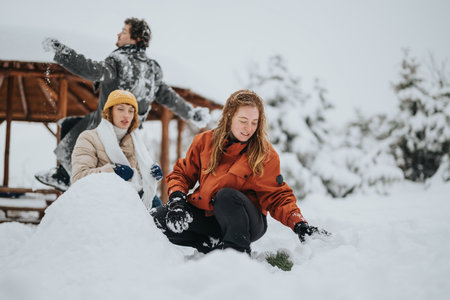 Three cheerful friends collaborate to build a snowman in a scenic snowy landscape, sharing laughter...