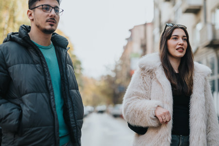Two young friends exploring the city streets on a cool dayの写真素材