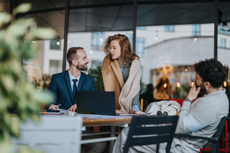 Colleagues Having a Conversation During an Outdoor Meeting at a Cafeの写真素材