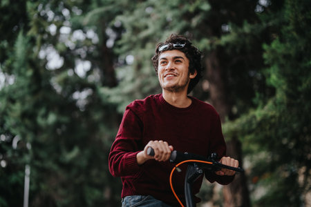 Young man enjoys riding electric scooter through forestの写真素材