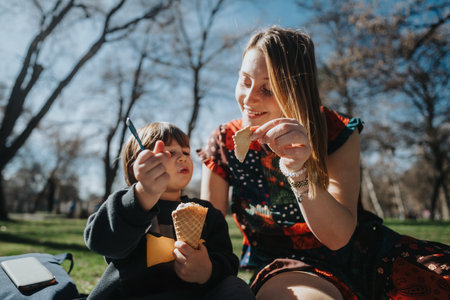 Mother and child enjoying ice cream together in a sunny parkの写真素材