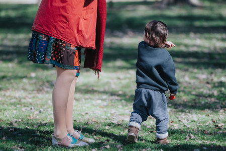 Young child and adult enjoying a sunny day at the parkの写真素材