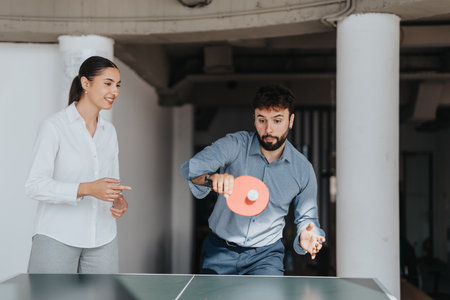 Business colleagues enjoying a friendly game of ping pongの写真素材