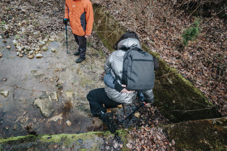 Outdoor hikers crossing a lush stream during an autumn exploration