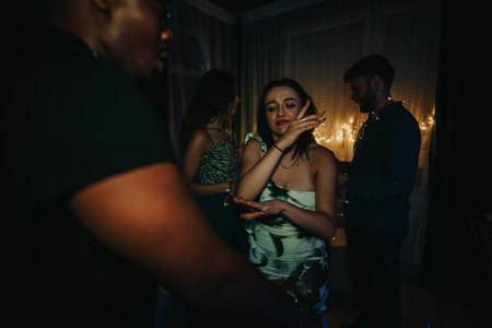 Group of friends celebrating indoors with dancing and festive atmosphereの写真素材