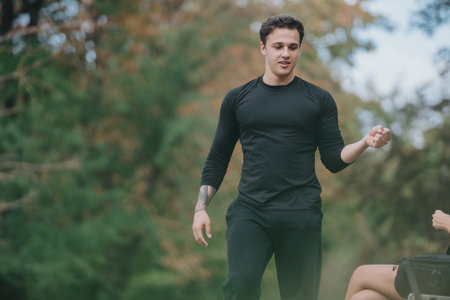 Man in black athletic attire enjoying a moment outdoors during a recreational activity in a scenic...