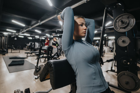 Person exercising in a gym environment using strength training equipmentの写真素材