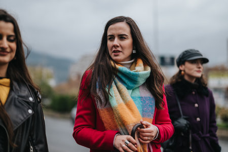 Group of fashionable women enjoying time together in a rain-soaked urban environmentの写真素材