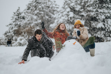 Three friends enjoying a playful snow day while building a snowman in a scenic snowy forest landscapeの写真素材
