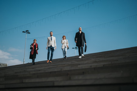Group of professional business colleagues walking together outdoors on a sunny day