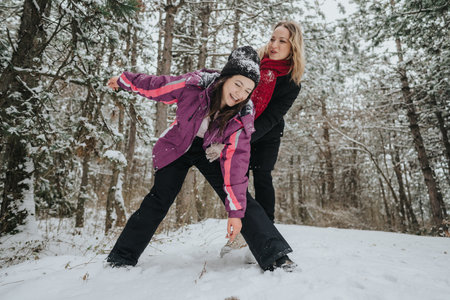 Two friends enjoying a playful moment in a snowy winter forestの写真素材