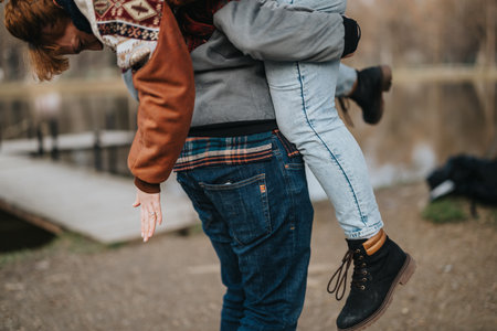 Playful couple spending a fun day outdoors near a scenic lake dockの写真素材