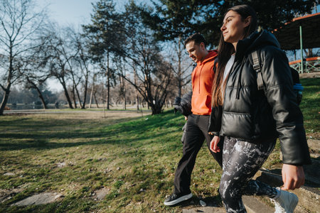 Two individuals enjoy a relaxing walk outdoors during a crisp sunny day in a peaceful park setting.の写真素材
