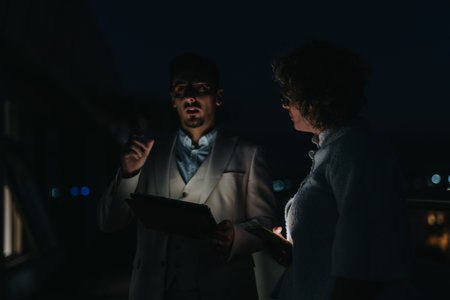 Business people discussing project strategies during a late night office meetingの写真素材