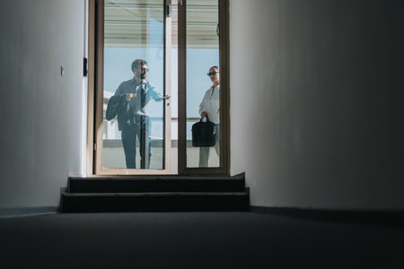 Business people standing on high rise balcony with city viewの写真素材