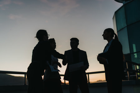 Business people shaking hands outside modern office buildingの写真素材