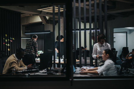 Busy office scene with diverse coworkers collaborating on projects at night