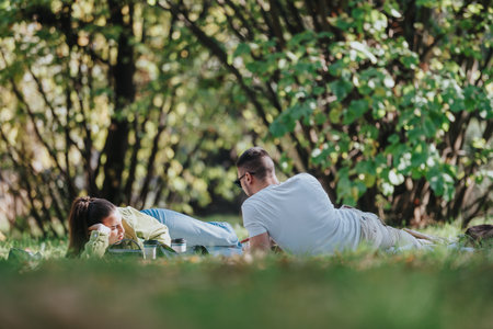 Couple enjoying a relaxing afternoon picnic in the parkの写真素材