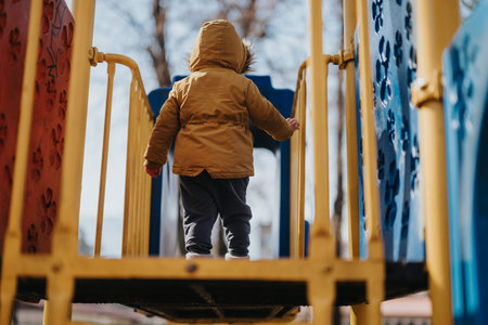 Child exploring playground equipment on a sunny dayの写真素材