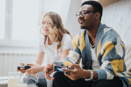 Diverse couple enjoying a video game session together in a cozy living roomの写真素材