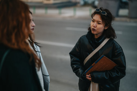 Conversation between women outdoors in a casual settingの写真素材