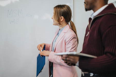Business professionals collaborating in an office setting during a presentationの写真素材