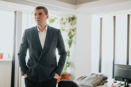 Professional businessman in modern office setting looking confident and composedの写真素材