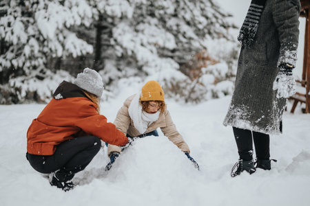 Family Enjoying Outdoor Winter Fun Building a Snowman Together in a Snowy Forest