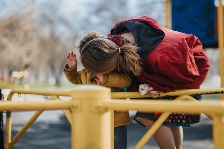 Mother Engaging with Child at Playground on a Sunny Dayの写真素材